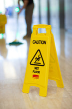 Rubbermaid FG611277YEL caution wet floor sign folded for storage